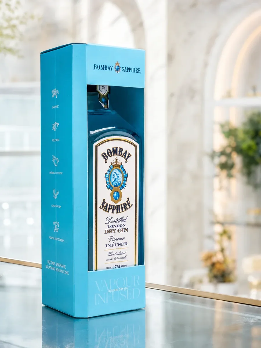 Karcsú világoskék italos díszdoboz Bombay Sapphire üveggel, napsütötte teraszon